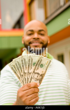 Man holding twenty dollar bills Stock Photo