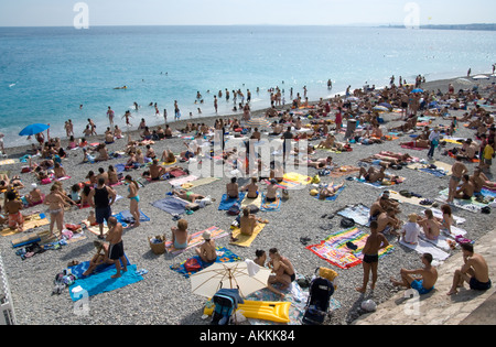 Crowds on the beach at Promenade des Anglais beach at Nice, Cote d'Azur, French Riviera, France Stock Photo