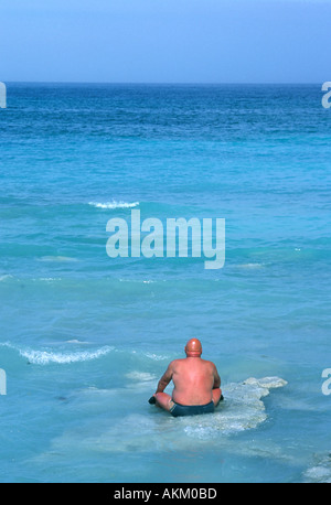 A man sunbathing in the mediterranean sea after taking a mud bath on the island of Vulcano in the Aolian Islands. Stock Photo