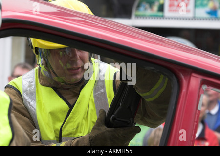 firemen treat an injured driver in a car crash scenario training exercise Stock Photo