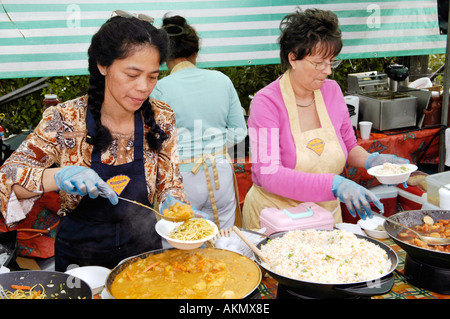 Women serving noodles on a stall at the annual food festival in Abergavenny Monmouthshire Wales UK GB Stock Photo