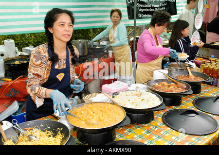 Women serving noodles on a stall at the annual food festival in Abergavenny Monmouthshire Wales UK GB Stock Photo