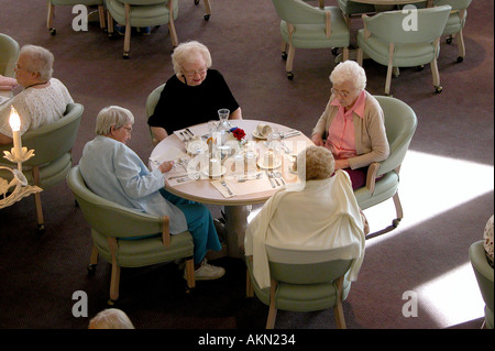 Senior citizen men and women talking and socializing at mealtime in a retirement complex Stock Photo