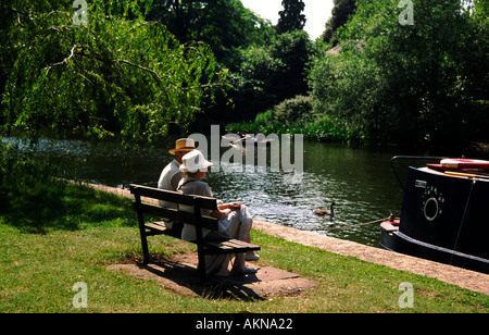 An elderly couple relax by the river Avon at Stratford upon Avon Warwickshire England UK Stock Photo