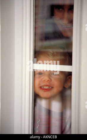 Pre school boy looking through window Stock Photo