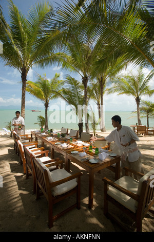 Waiters setting the table in the beach restaurant of the Santiburi Dusit Resort Mae Nam Beach Hat Mae Nam Ko Samui Thailand Stock Photo