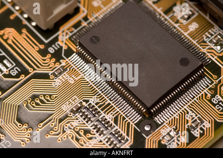 Digital close up photograph of the insides of a computer circuit board including a computer chip and circuits Stock Photo