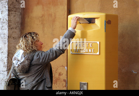 Woman throwing her mail into a mailbox of the Vatican Post Stock Photo
