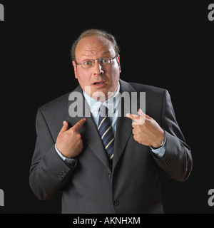 Image of middle age caucasian man in suit looking surprised pointing at himself Stock Photo