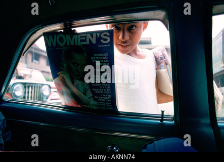 Boy sells magazines at car windows in Manila Philippines Stock Photo