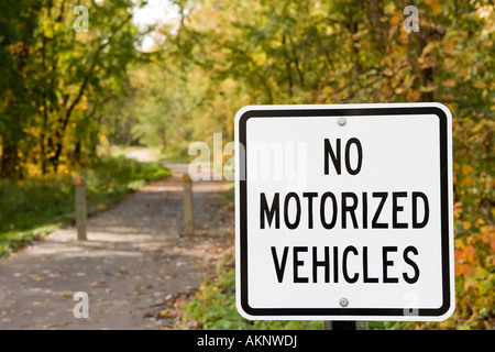 No Motorized Vehicles sign at the head of a bike trail with autumn leaves Stock Photo