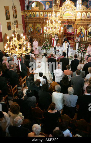 A packed typical Greek Orthodox church during a wedding ceremony UK Stock Photo