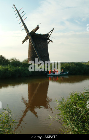Family fishing in a boat in front of Brograve Drainage Mill, Horsey, Norfolk, England, UK. Stock Photo
