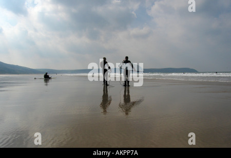 two surfers walking on beach Stock Photo