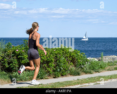 A fit woman running near the ocean Stock Photo