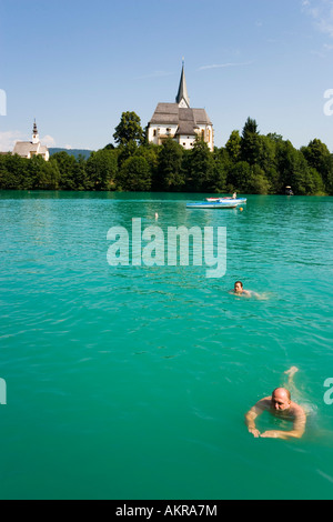 People swimming in the Worthersee  Parish Church and Rosary Church Maria Worth Carinthia Austria Stock Photo