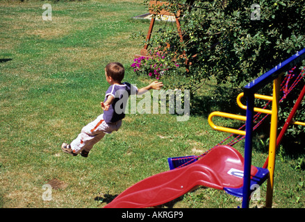 Boy jumping from a swing seesaw, danger Stock Photo