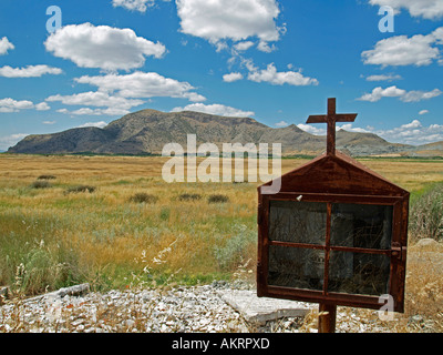 little ramshackle alter in a glas cabinet case with picture of saints and a candle at the roadside on the edge of a field Stock Photo