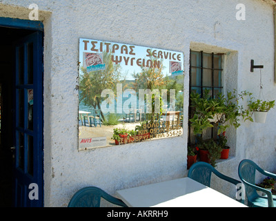 greek kafenion bar restaurant with a mirror on the wall reflecting the view of the sea and waves splashing against the wall Stock Photo