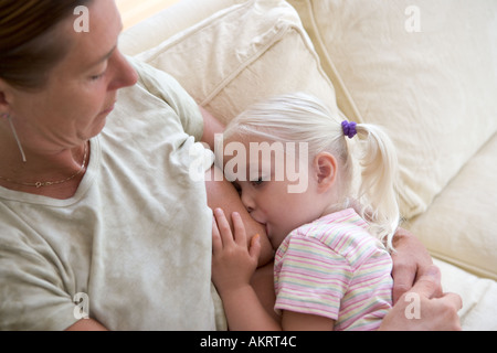 Breastfeeding a 3 year old girl Stock Photo