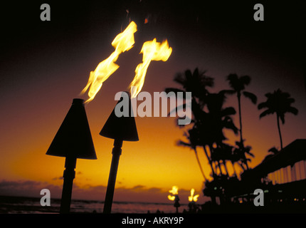 Torches at sunset on the patio of a Waikiki Beach hotel Stock Photo