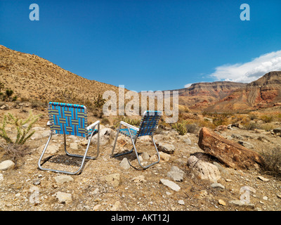 Empty plaid lawn chairs in desert landscape Stock Photo