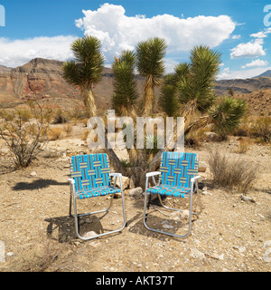 Empty plaid lawn chairs in desert landscape Stock Photo