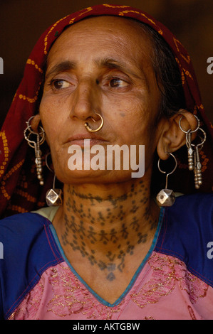 A Rabari woman sits at Than Monastery. Rabari women usually wear black  skirts and blouses edged with elaborate embroidery, as well as plentiful  jewellery and tattoos. - SuperStock