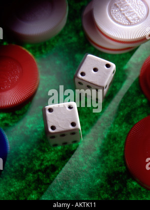 still life 2 two dice die red white poker chips on green textured background 3 three four 4 7 seven point shaft of light Stock Photo