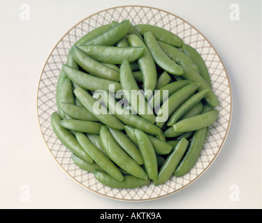 medley of green pea pods on gold rim plate frozen vegetables Bon Appetit Stock Photo