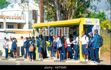 School children waiting for bus home after school - 'Mauritius'. Stock Photo