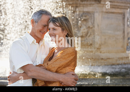 Middle-aged couple hugging by fountain, Rome, Italy, close up Stock Photo