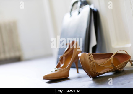 High heels and briefcase on domestic hallway floor, close up Stock Photo