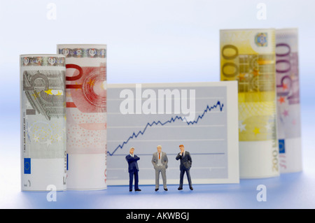 Figurines of businessmen in front of graph