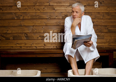 Germany, senior man having foot bath in health spa Stock Photo