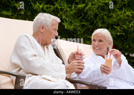 Germany, senior couple drinking smoothie in spa Stock Photo