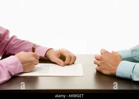 Businessmen sitting at conference table opposite each other, close-up Stock Photo