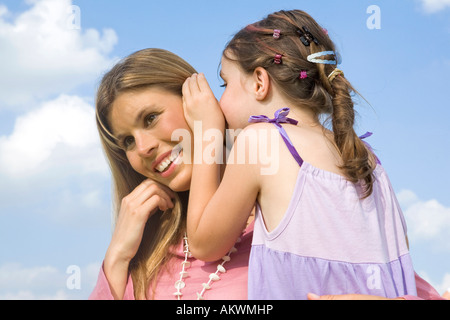 Daughter whispering in mother´s ear Stock Photo