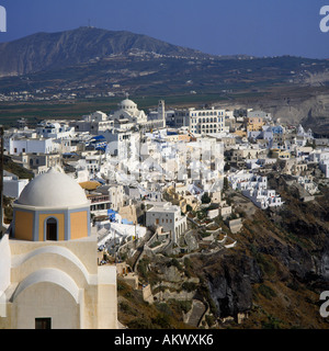 Cliff top view of white clustered buildings of town with domed roof of church in foreground Fira on Santorini Greek Islands Stock Photo