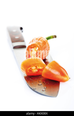Orange Fresno pepper on knife blade, close-up Stock Photo