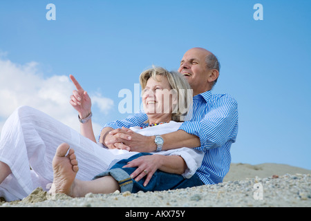Mature couple sitting on beach Stock Photo