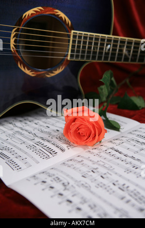 Blue acoustic guitar with roses and sheet music Stock Photo