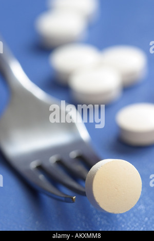 Pill tablet medicine drug on everyday fork concept Stock Photo