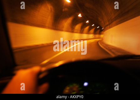 Car Driving Through a Subterranean Tunnel Under a Mountain Viewed from the Vehicle Interior Stock Photo