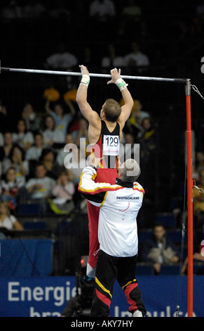 Fabian HAMBUeCHEN GER at the Gymnastics World Cup in Stuttgart 2006 at high bar supported by father and trainer Wolfgang HAMBUe Stock Photo