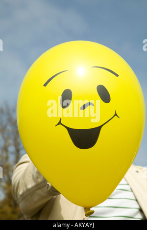 Man holding a balloon in front of his face Stock Photo