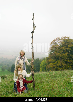 Germany, Baden-Württemberg, Swabian mountains, grandmother with granddaughters in landscape, holding branch Stock Photo