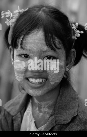 Burmese girl wearing thanakha with mimosa in her hair at a local market, Bagan, Burma, (Myanmar) Stock Photo