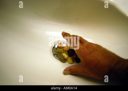 throwing money down drain Stock Photo