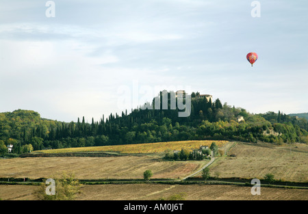 A hot air balloon flies over a villa, Tuscany, Italy Stock Photo